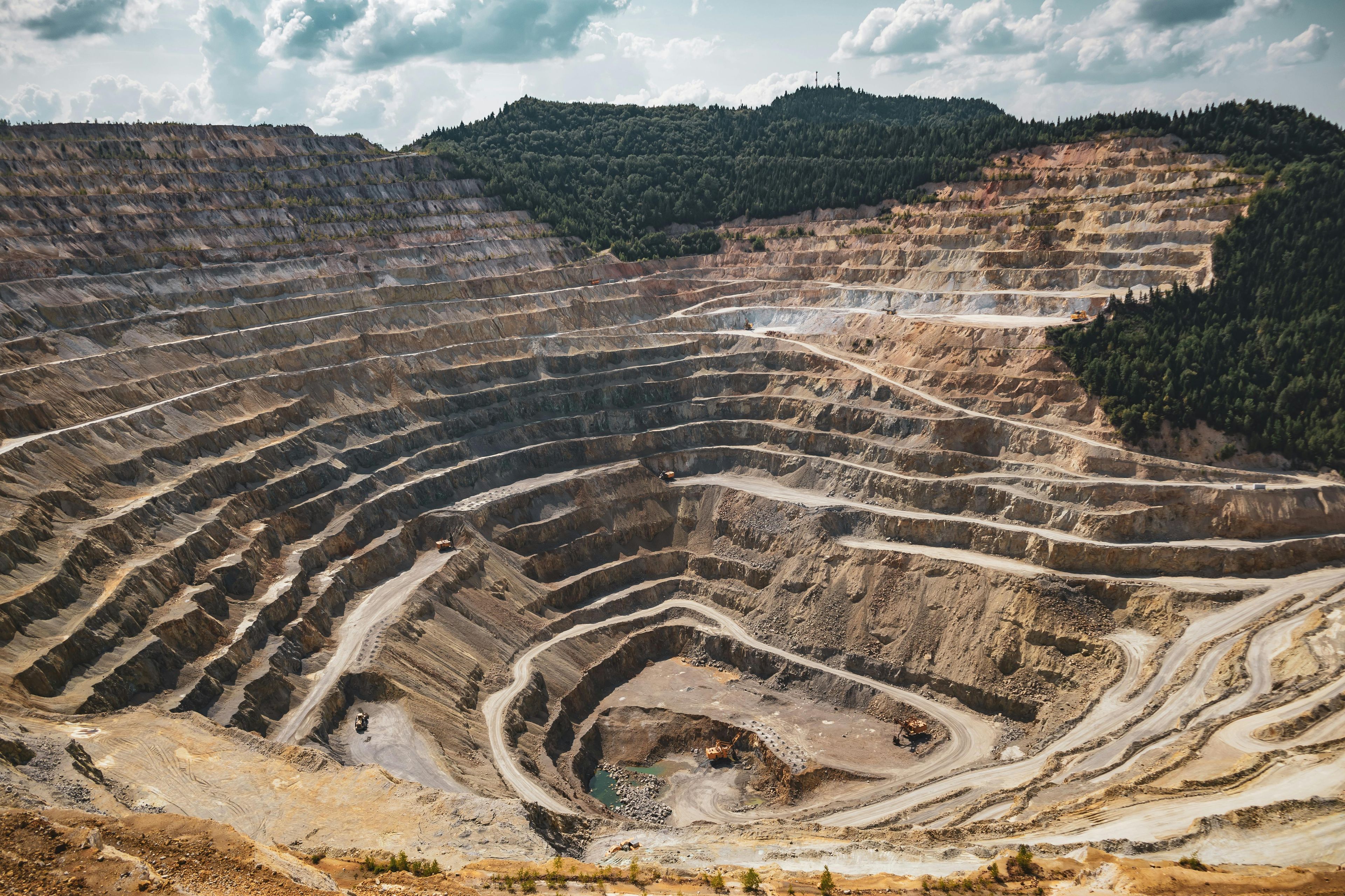 Land mine excavation with terraced levels of stair-like digging, showcasing open-pit mining operations